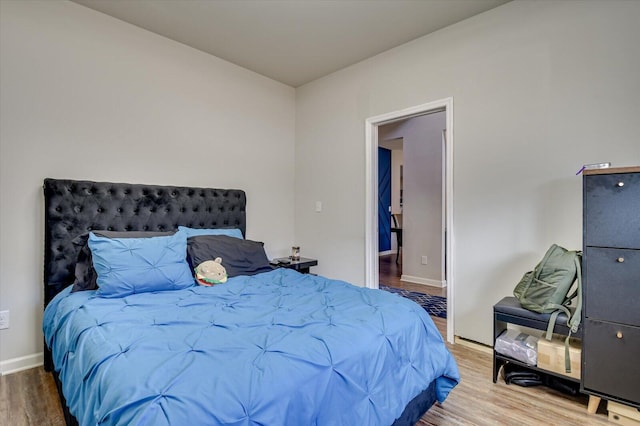 bedroom featuring wood finished floors and baseboards