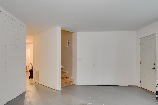 unfurnished room with stairway and concrete flooring