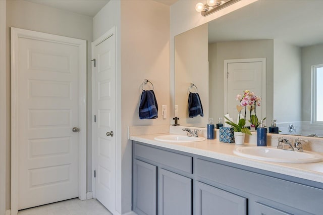 bathroom featuring double vanity, a closet, and a sink