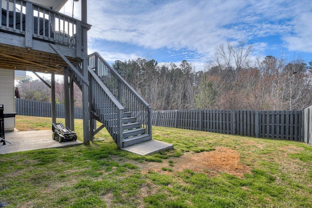 view of yard with stairs, a patio, a deck, and a fenced backyard