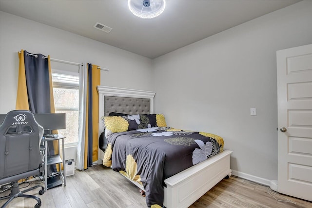 bedroom with visible vents, light wood-style flooring, and baseboards