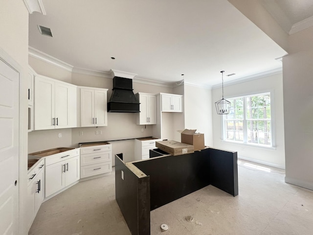 1009 Ferndown Ct, Aiken, SC 29803 - kitchen with premium range hood, a kitchen island, ornamental molding, white cabinets, and decorative light fixtures