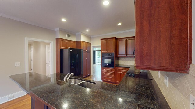 135 Coach Ln, Augusta, GA 30907 - kitchen featuring a peninsula, a sink, visible vents, backsplash, and black appliances