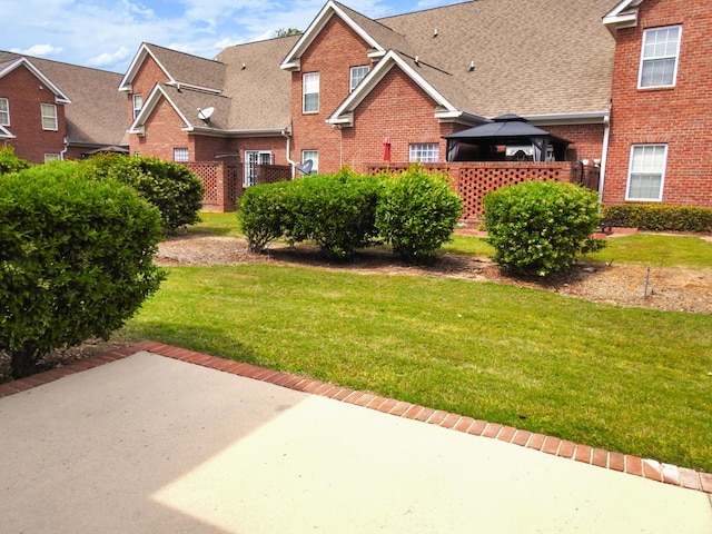 135 Coach Ln, Augusta, GA 30907 - traditional home featuring a gazebo, a front lawn, a patio, brick siding, and roof with shingles