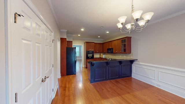 135 Coach Ln, Augusta, GA 30907 - kitchen with dark countertops, crown molding, black appliances, a chandelier, and a peninsula