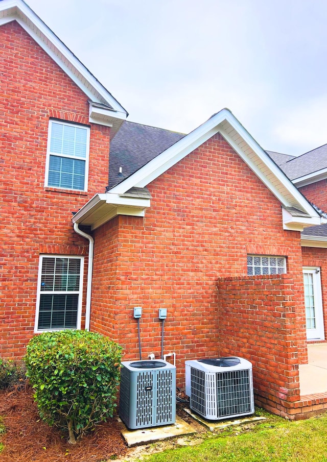 135 Coach Ln, Augusta, GA 30907 - view of side of home featuring a shingled roof, brick siding, and central AC unit