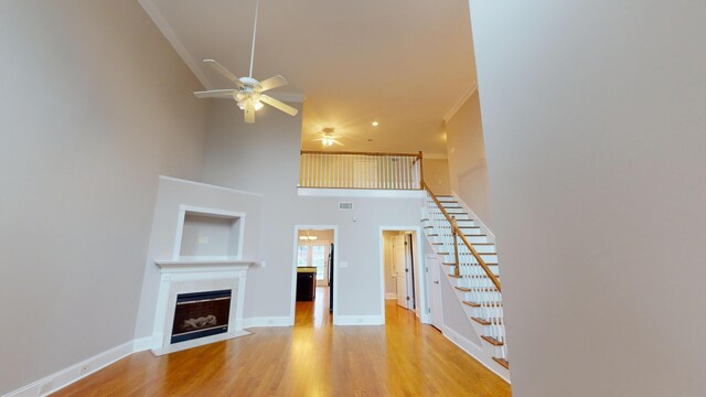 135 Coach Ln, Augusta, GA 30907 - unfurnished living room featuring a fireplace with flush hearth, visible vents, a ceiling fan, a high ceiling, and stairway
