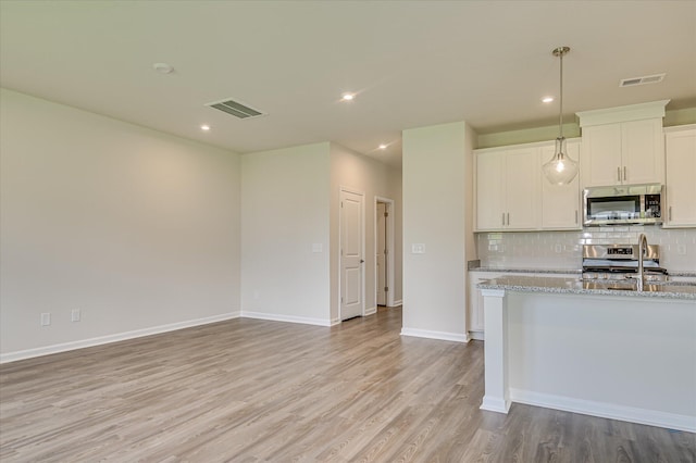 909 Kay Pl, Grovetown, GA 30813 - kitchen featuring stainless steel appliances, light wood-style flooring, backsplash, white cabinetry, and light stone countertops