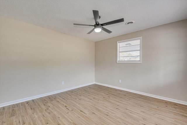 unfurnished room with baseboards, a textured ceiling, light wood-style floors, visible vents, and ceiling fan