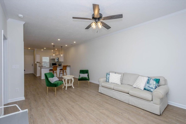 living room featuring crown molding, ceiling fan, light hardwood / wood-style floors, and a textured ceiling