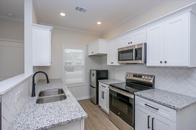 kitchen featuring sink, ornamental molding, white cabinets, and appliances with stainless steel finishes