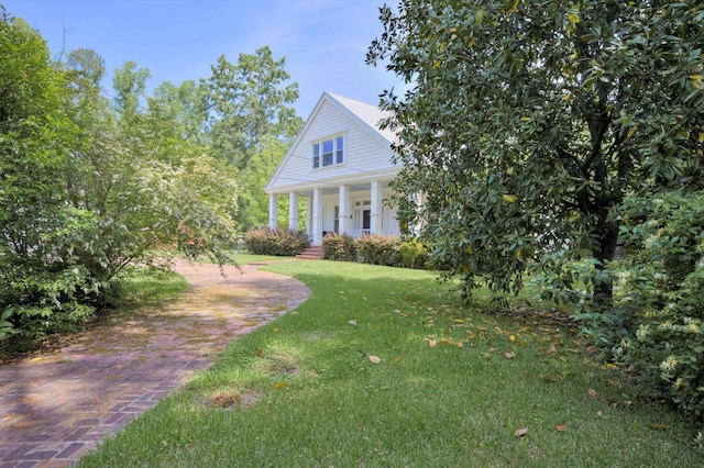 greek revival inspired property with covered porch and a front yard