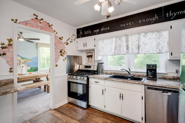 kitchen with ceiling fan, a sink, dark wood finished floors, stainless steel appliances, and white cabinetry