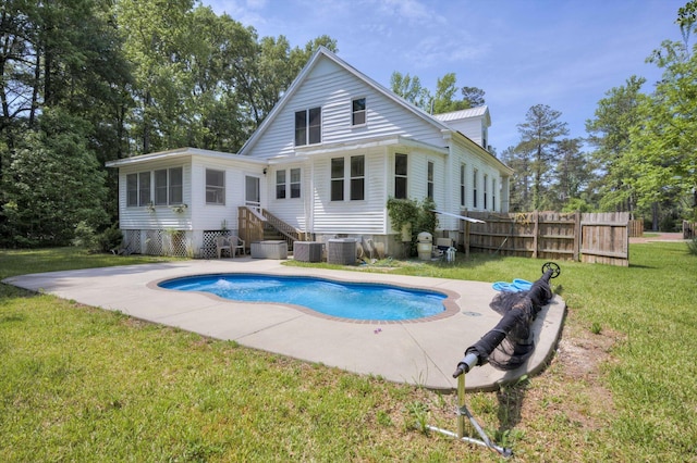 back of property with a fenced in pool, central AC unit, and a yard
