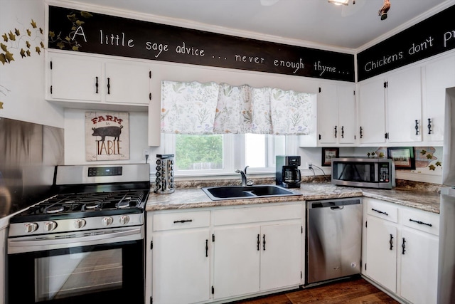kitchen featuring dark wood-style flooring, white cabinetry, appliances with stainless steel finishes, and a sink