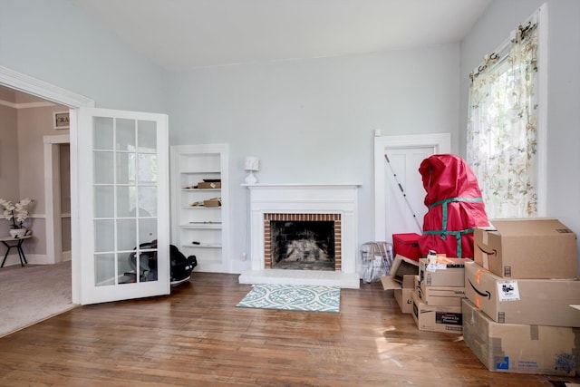 living area featuring a brick fireplace and wood finished floors
