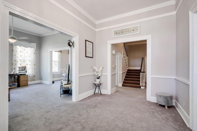 hall with baseboards, ornamental molding, carpet, and stairs