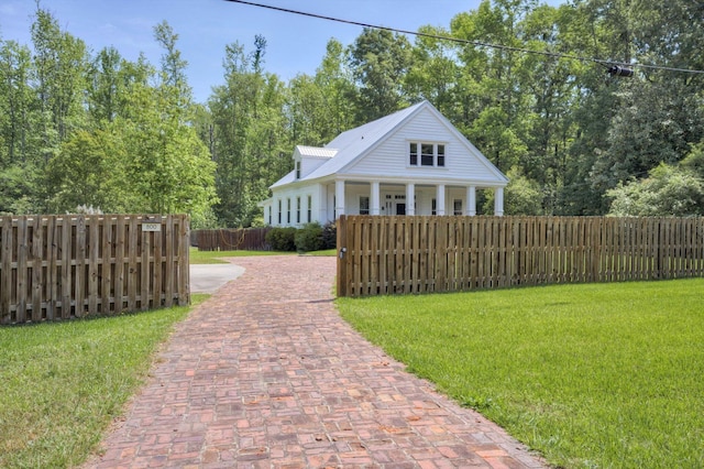 view of front of property featuring covered porch, a fenced front yard, and a front yard