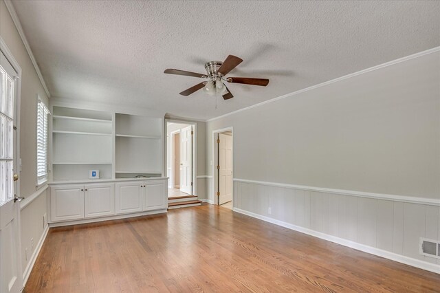 986 Campbellton Dr, North Augusta, SC 29841 - unfurnished room with a textured ceiling, light wood-style floors, a ceiling fan, crown molding, and built in shelves