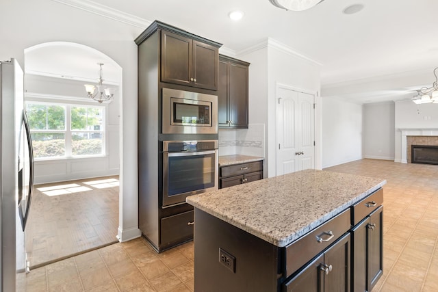 207 Hazelwood Ct, Grovetown, GA 30813 - kitchen with appliances with stainless steel finishes, ornamental molding, dark brown cabinets, a chandelier, and light stone countertops