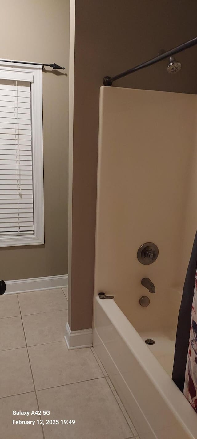 full bath featuring tile patterned flooring, shower / bath combo, and baseboards