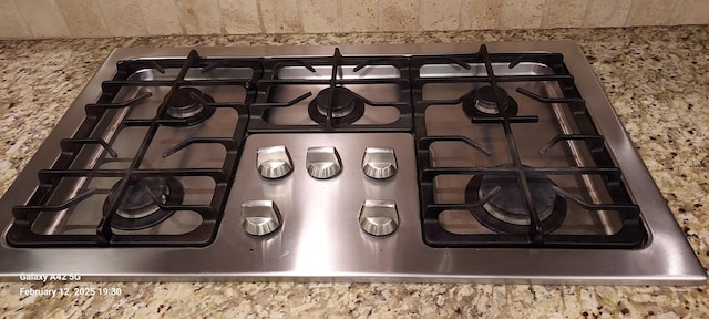 room details featuring light stone countertops and stove