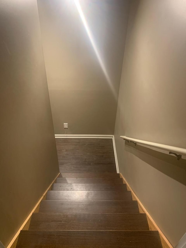 stairway featuring hardwood / wood-style flooring and baseboards