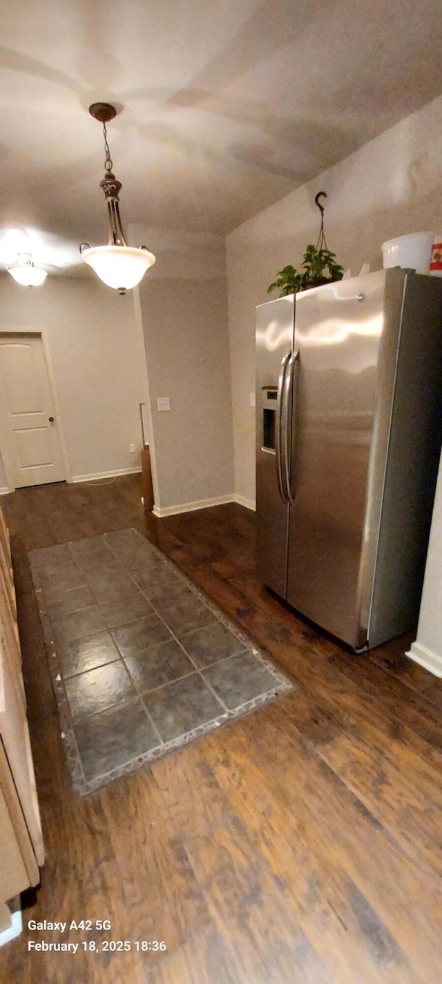 kitchen with pendant lighting, dark wood finished floors, stainless steel refrigerator with ice dispenser, and baseboards