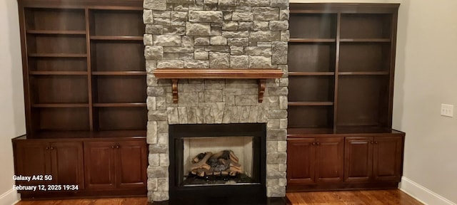 unfurnished living room with a fireplace, wood finished floors, and baseboards