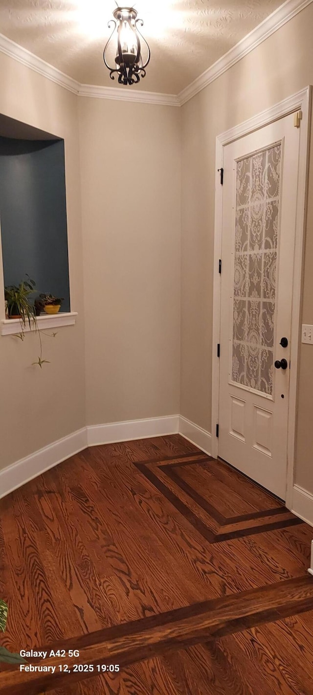 entryway with crown molding, baseboards, and wood finished floors