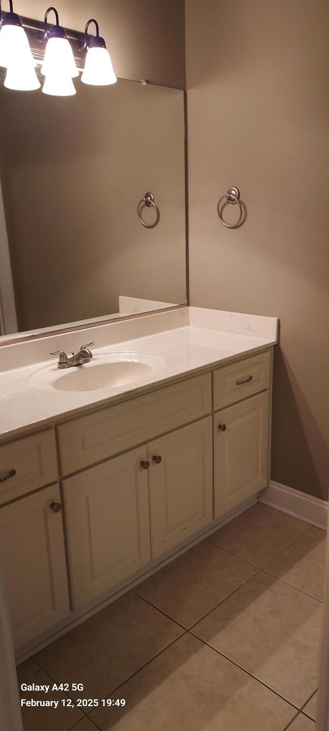 bathroom featuring tile patterned flooring, a notable chandelier, and vanity