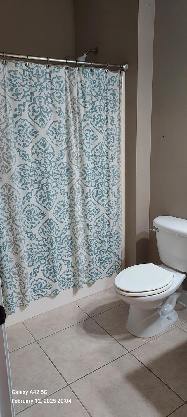 bathroom with toilet and tile patterned floors