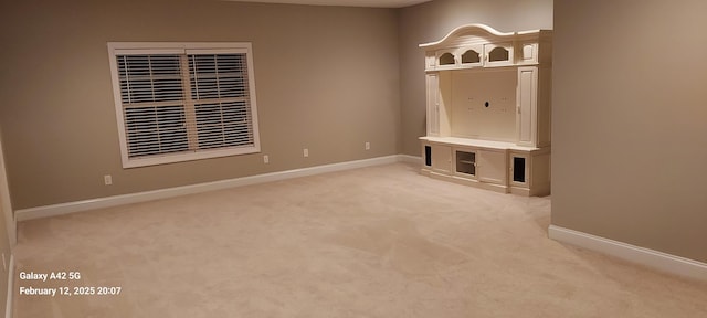 mudroom featuring light carpet and baseboards