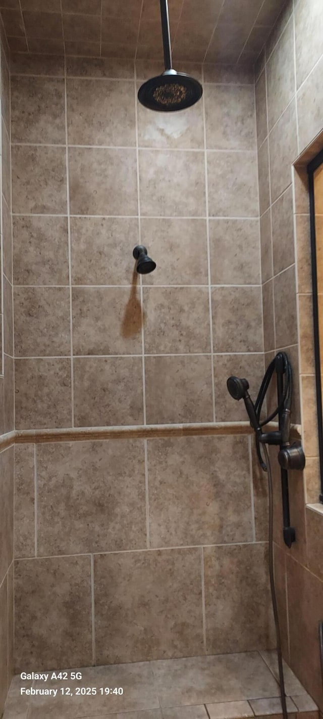 interior details featuring a tile shower