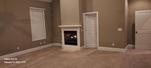 unfurnished living room featuring light carpet, a multi sided fireplace, and baseboards