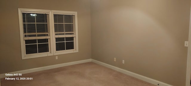 carpeted spare room with baseboards