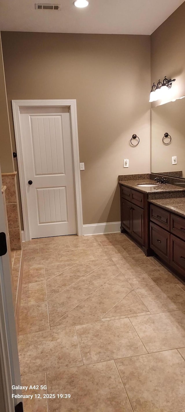 bathroom featuring visible vents, vanity, and baseboards