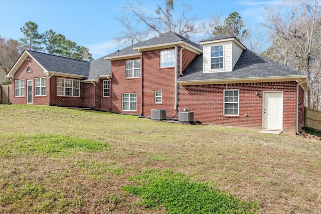 back of house featuring fence, a yard, central AC unit, and brick siding