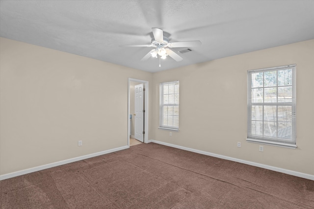 unfurnished room featuring a ceiling fan, carpet, visible vents, and baseboards