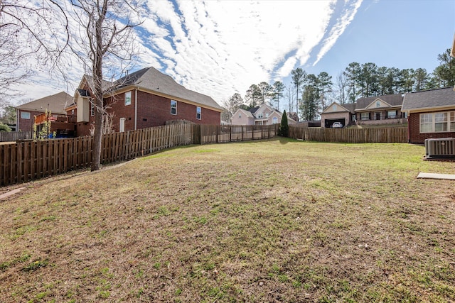 view of yard with a residential view, central AC unit, and a fenced backyard