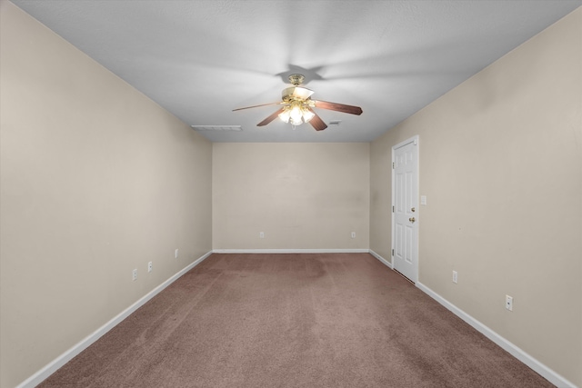 carpeted spare room with visible vents, baseboards, and a ceiling fan