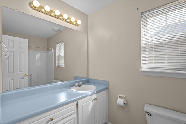 bathroom with vanity, toilet, and walk in shower