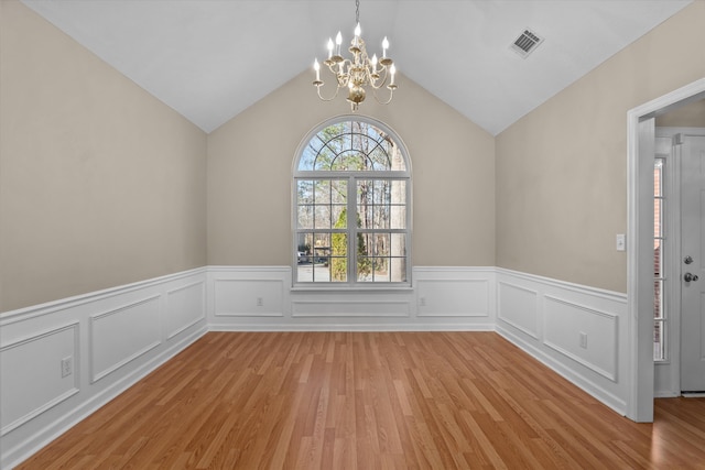 unfurnished dining area with visible vents, light wood-style flooring, lofted ceiling, and an inviting chandelier