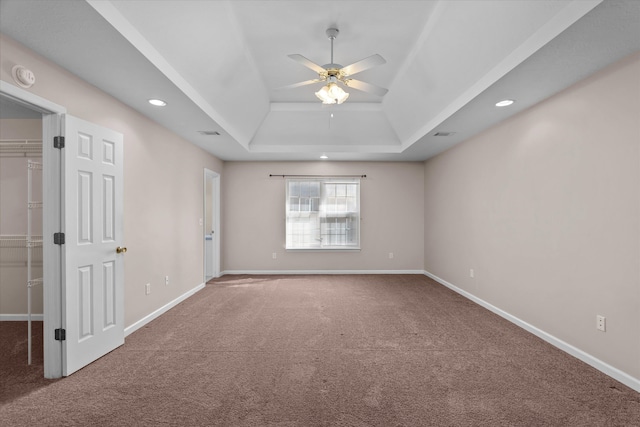 carpeted empty room featuring a ceiling fan, baseboards, visible vents, recessed lighting, and a raised ceiling