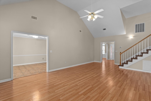 unfurnished living room featuring visible vents, stairway, and light wood-type flooring