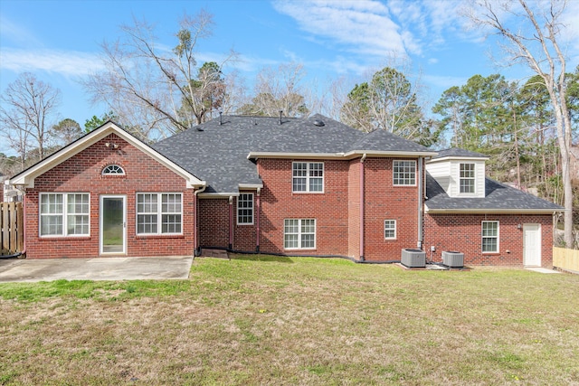 back of property featuring central air condition unit, a patio, a yard, and brick siding