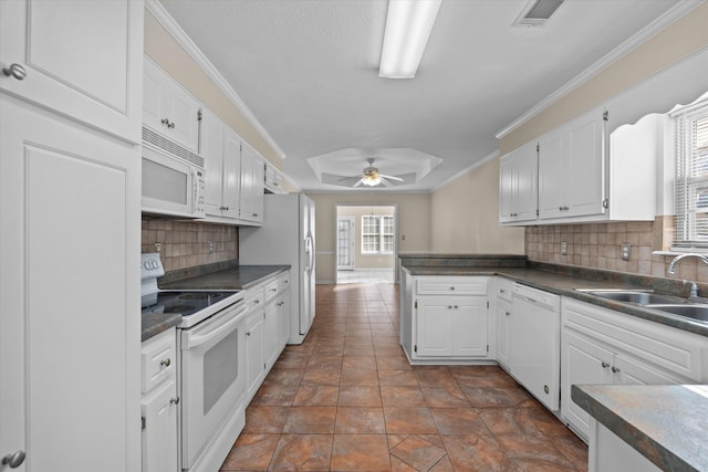 kitchen featuring white cabinets, white appliances, crown molding, and a sink