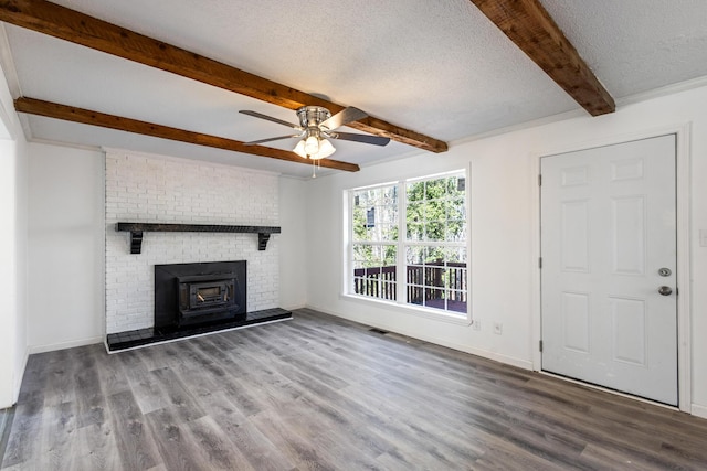 unfurnished living room featuring beamed ceiling, a textured ceiling, and wood finished floors