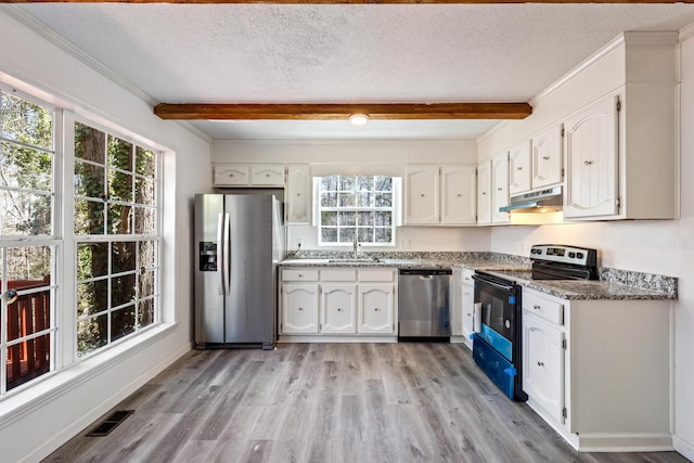 kitchen with under cabinet range hood, stainless steel appliances, a sink, white cabinetry, and beam ceiling