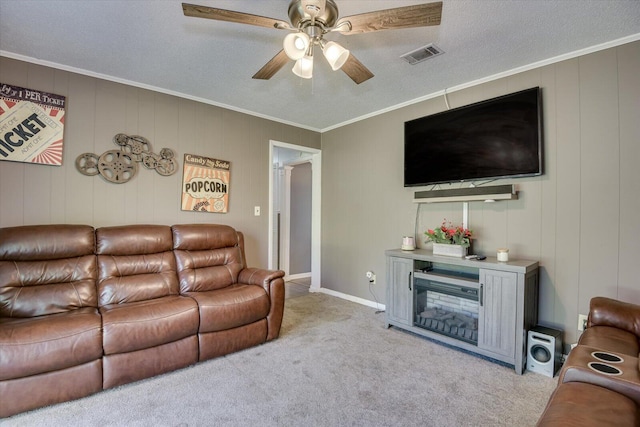 carpeted living room featuring ceiling fan, a textured ceiling, and ornamental molding